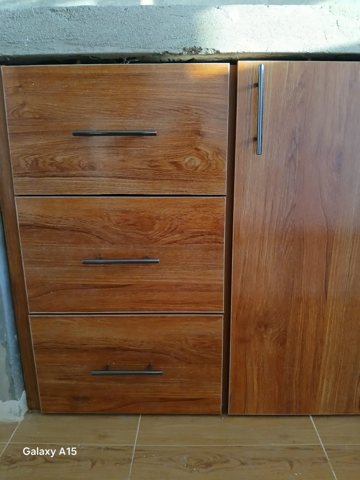 Warm wood grain and dark handles on fitted drawers